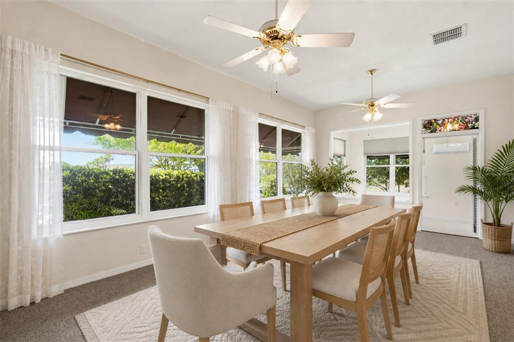 A dining room features a wooden table, cane-back chairs, two ceiling fans, and large windows — 1075 MOTORCOACH DRIVE, POLK CITY, FL