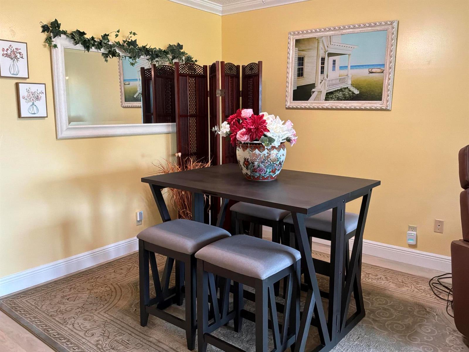 A dining area features a dark wood table with four stools on a patterned rug — 1121 Cactus Terrace # 202, Delray Beach FL 33445, DELRAY BEACH, FL