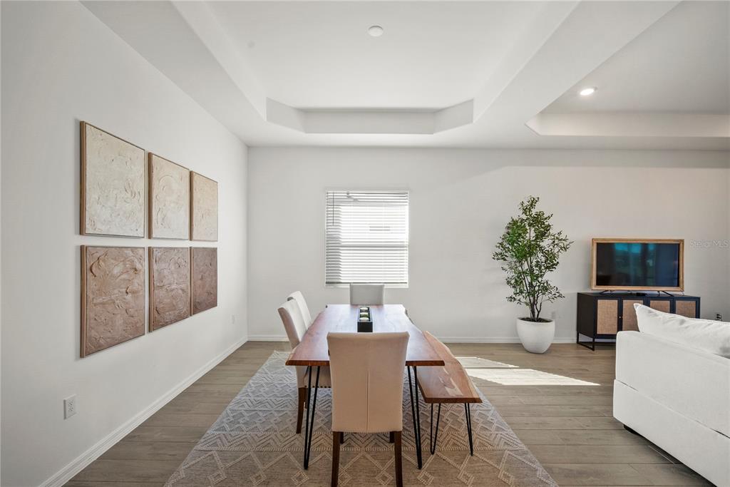 A dining room features a wooden table, upholstered chairs, a bench, and wall art — 15916 N SUGAR HILL DRIVE, PUNTA GORDA, FL