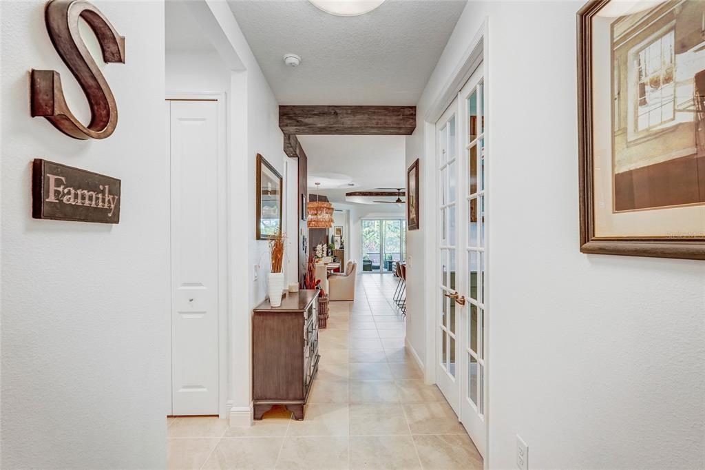 A bright hallway features tile flooring, a wooden ceiling beam, and French doors — 10233 LAKE WALES CIRCLE, SARASOTA, FL