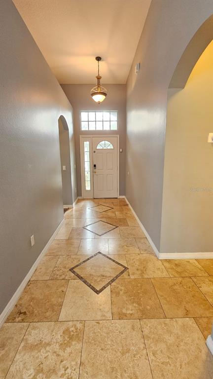 A single-story house with a two-car garage, light green stucco exterior, and a front lawn — 2713 BARNSLEY LANE, KISSIMMEE, FL