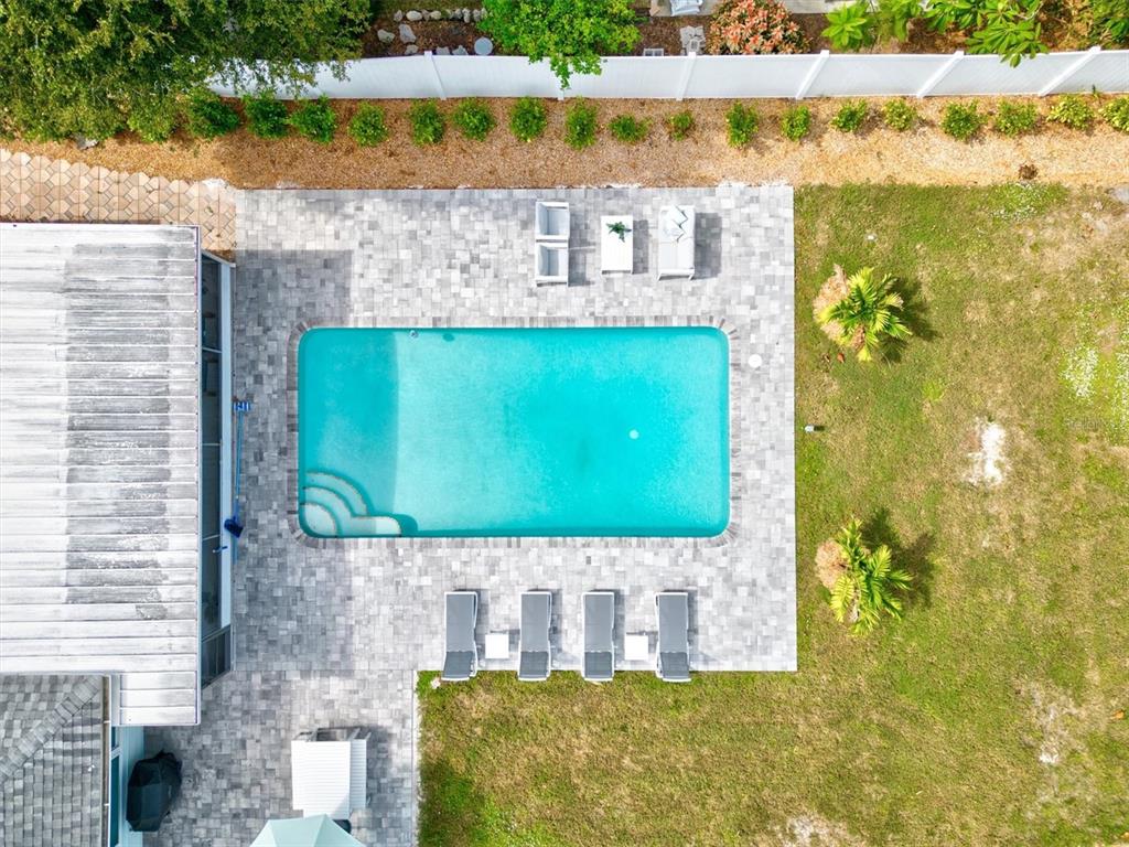 An aerial view shows a rectangular swimming pool surrounded by a paved patio and lawn — 2641 MARTIN STREET, SARASOTA, FL
