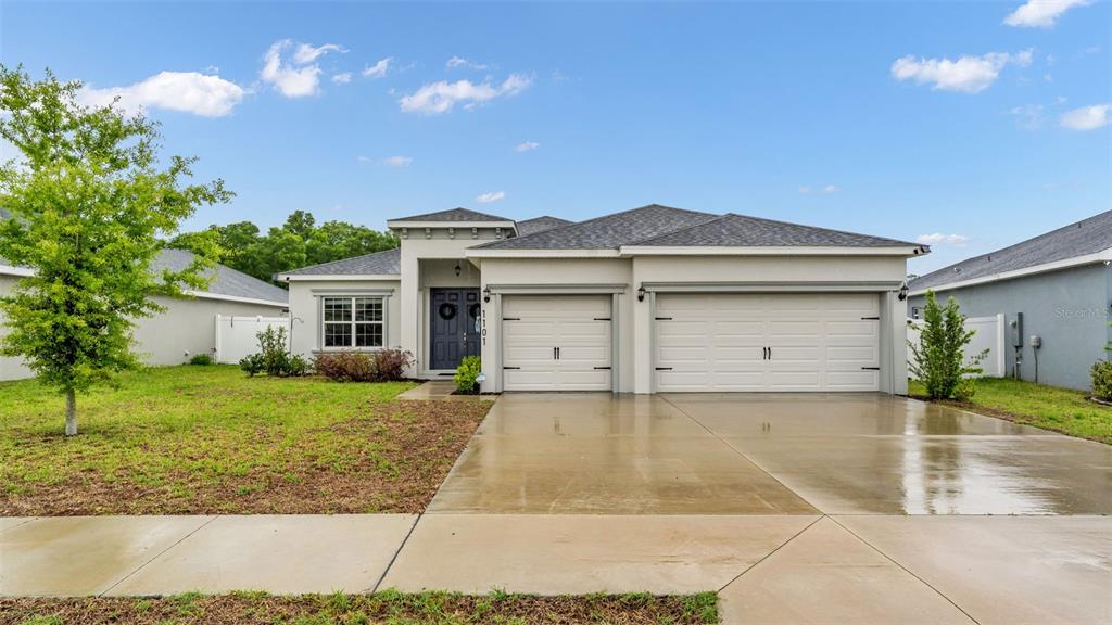 A single-story house with a two-car garage, a gray roof, and a concrete driveway — 1101 MONTGOMERY LANE, POLK CITY, FL