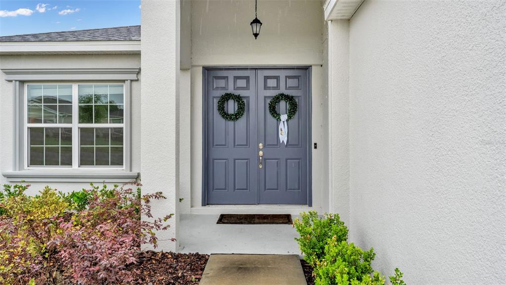 A front entryway features a double door with wreaths and a window to the left — 1101 MONTGOMERY LANE, POLK CITY, FL