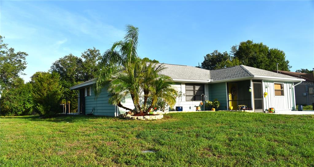 A light blue single-story house with a palm tree in the front yard — 335 HARBOR BOULEVARD, PORT CHARLOTTE, FL