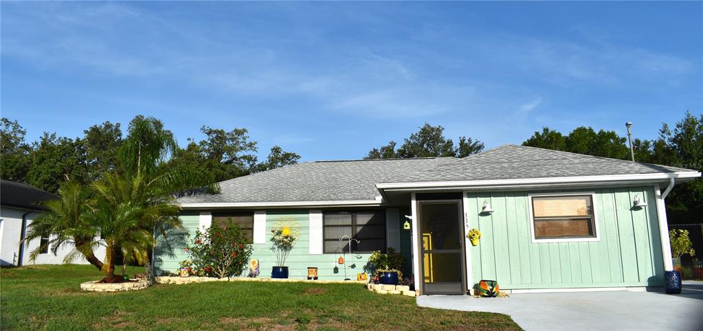 A light green, single-story house with a palm tree and a paved driveway — 335 HARBOR BOULEVARD, PORT CHARLOTTE, FL