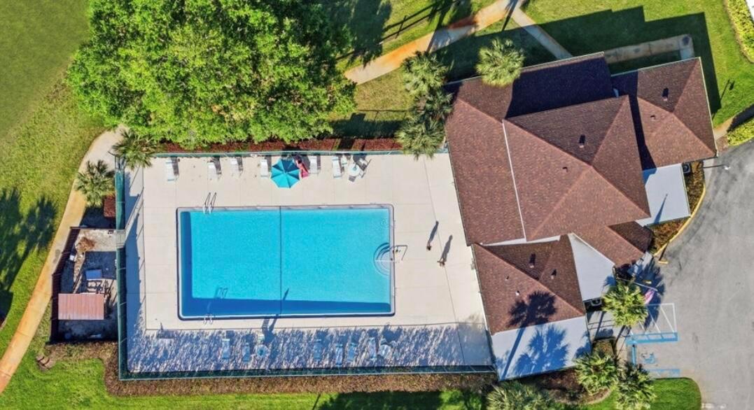 An aerial view shows a rectangular swimming pool with lounge chairs next to a building — 1723 Mariners Cove # A, Fort Pierce FL 34950, FORT PIERCE, FL