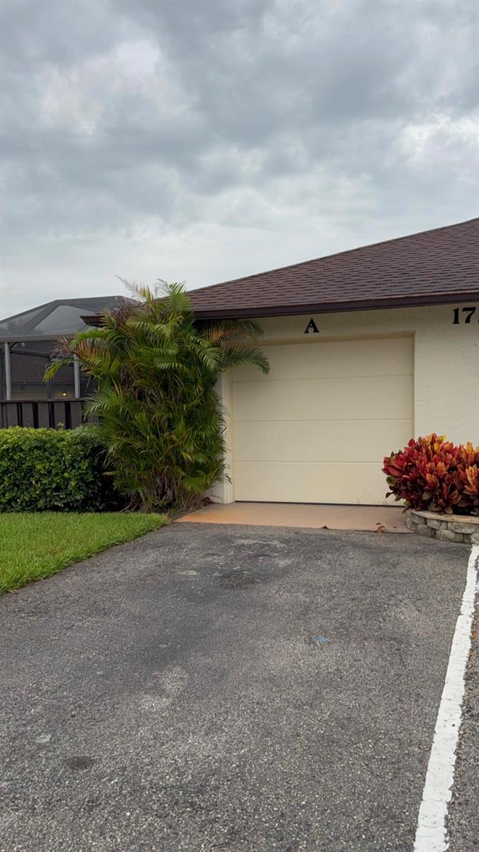 A beige garage door with the letter A above it sits next to a palm tree — 1723 Mariners Cove # A, Fort Pierce FL 34950, FORT PIERCE, FL