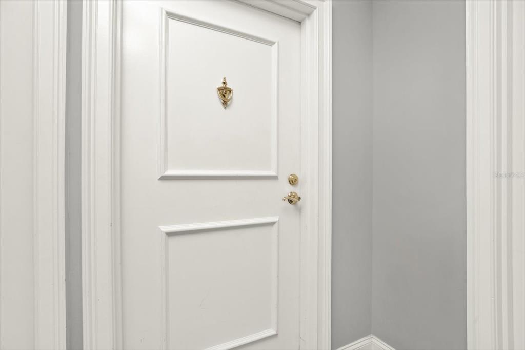 A white interior door features a gold door knocker and a gold handle — 345 BAYSHORE BOULEVARD UNIT 302, TAMPA, FL