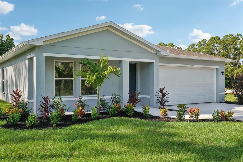 A single-story house with a gray exterior, a two-car garage, and a landscaped front yard — 3509 DAHLIA DRIVE, LAKE HAMILTON, FL