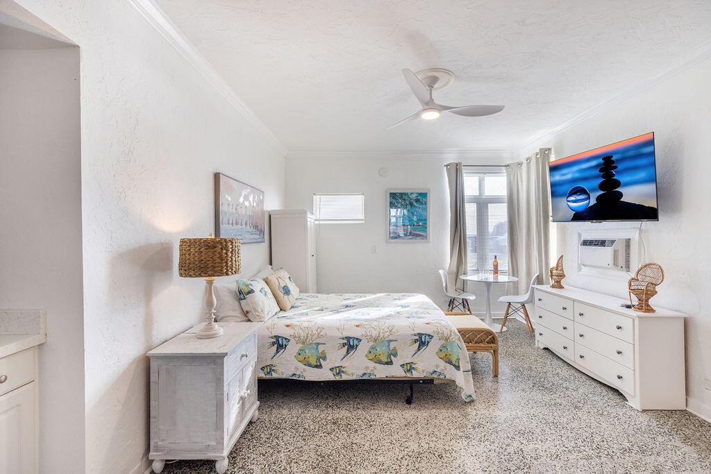 A bedroom features a bed with fish-patterned bedding, a white dresser, and a wall-mounted television — 88 S Ocean Boulevard, Delray Beach FL 33483, DELRAY BEACH, FL