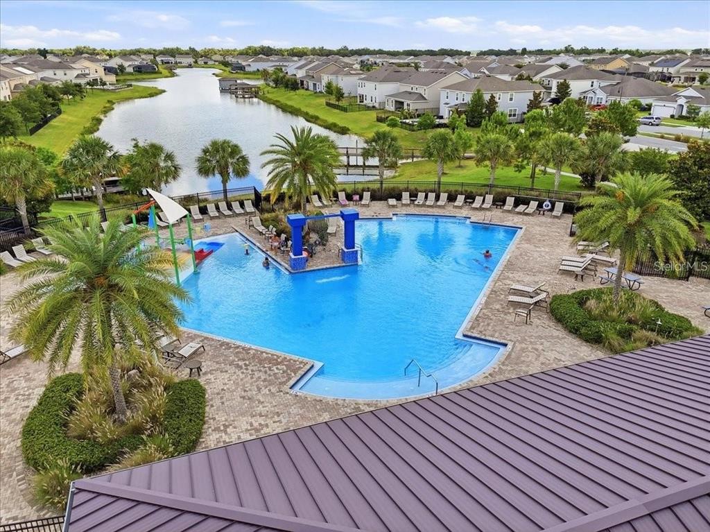 An elevated view of a community swimming pool surrounded by palm trees and houses — 2695 NOTTEL DRIVE, ST CLOUD, FL