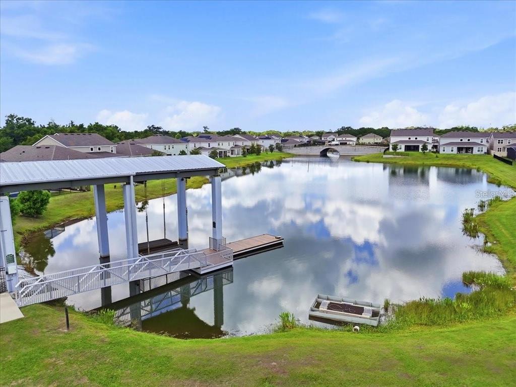 An aerial view shows a boat dock and pier extending into a pond near houses — 2695 NOTTEL DRIVE, ST CLOUD, FL