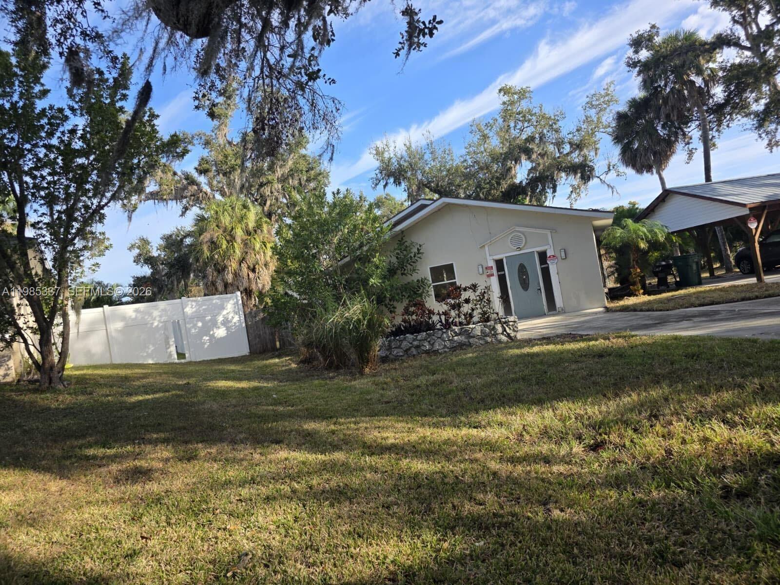 A single-story house with a light-colored exterior, a front porch, and a white privacy fence — 3661 Bernice LN, Sarasota FL 34238, SARASOTA, FL