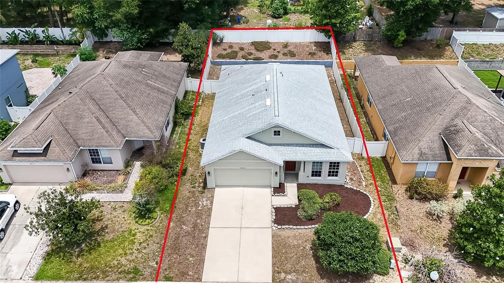 An aerial view shows a single-story house with a gray roof and a fenced backyard — 25143 CHIPSHOT COURT, SORRENTO, FL