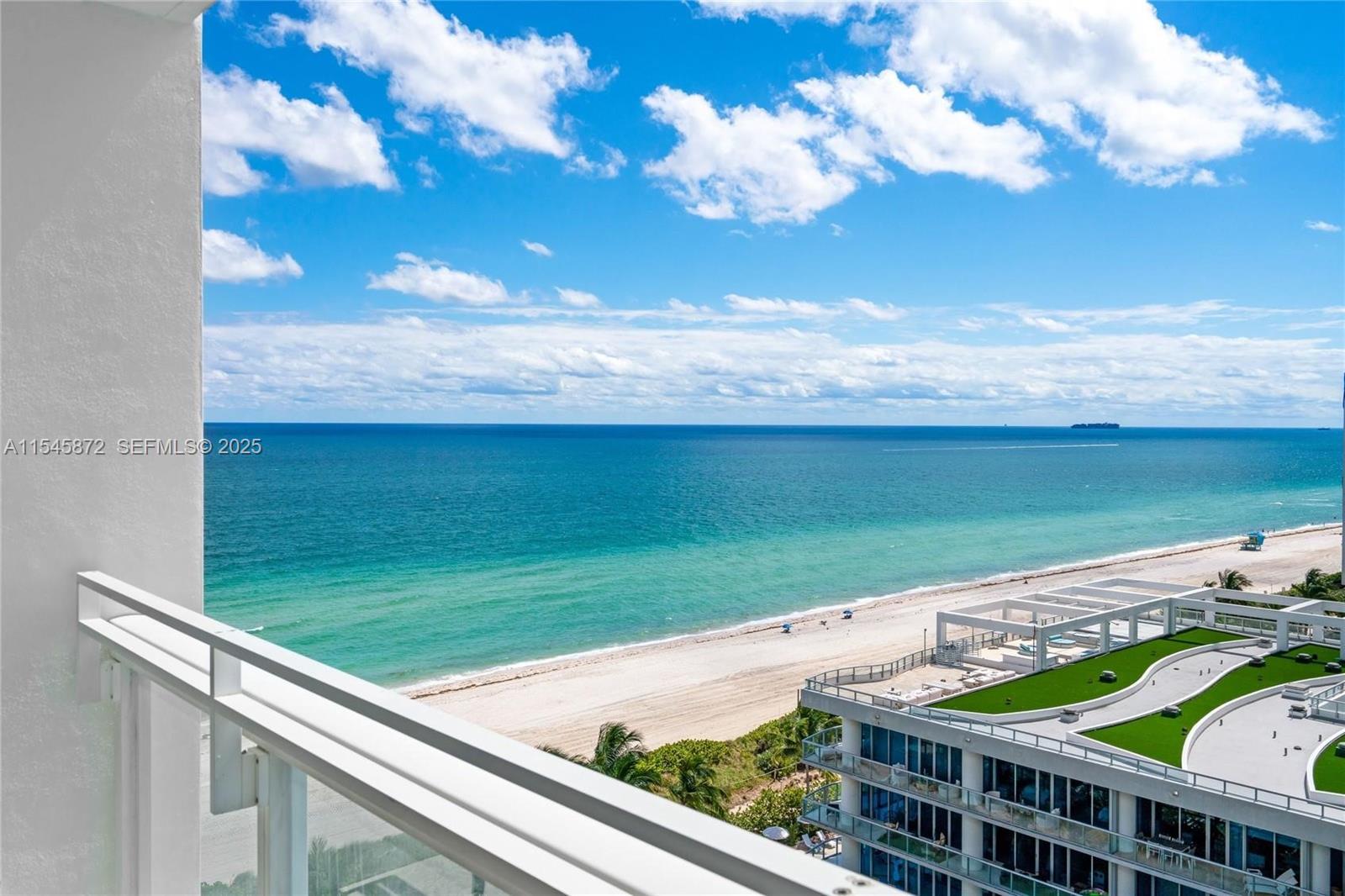 A high-angle view from a balcony overlooking a sandy beach and the ocean — 6801 Collins Ave # 1206, Miami Beach FL 33141, MIAMI BEACH, FL