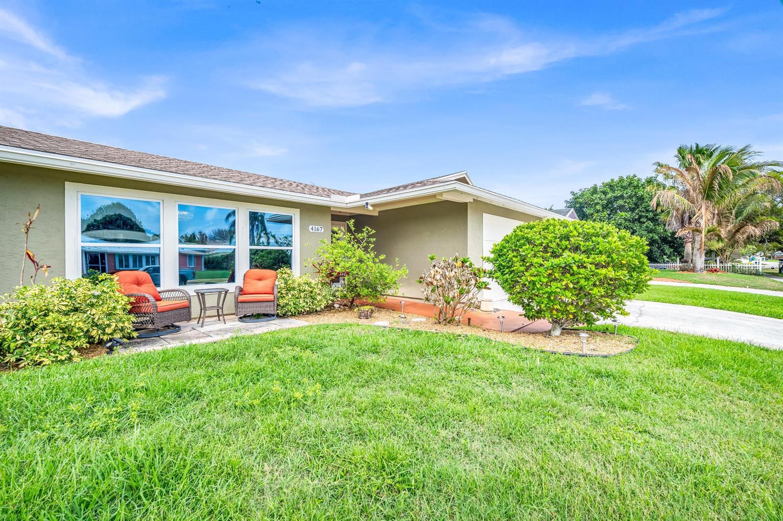 A single-story house with a green exterior, a front patio, and a manicured lawn — 4167 Russell Street, Jupiter FL 33469, JUPITER, FL