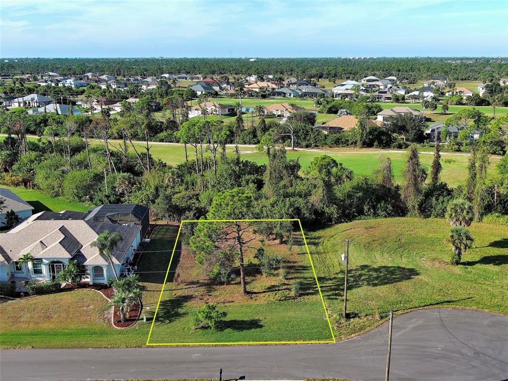 An aerial view shows a vacant residential lot outlined in yellow next to a house — 43 TEE VIEW ROAD, ROTONDA WEST, FL