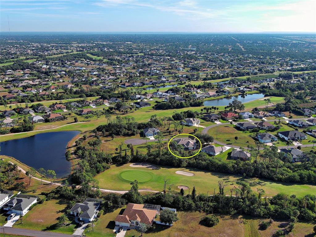 An aerial view shows a residential house circled in yellow, situated near a golf course — 43 TEE VIEW ROAD, ROTONDA WEST, FL