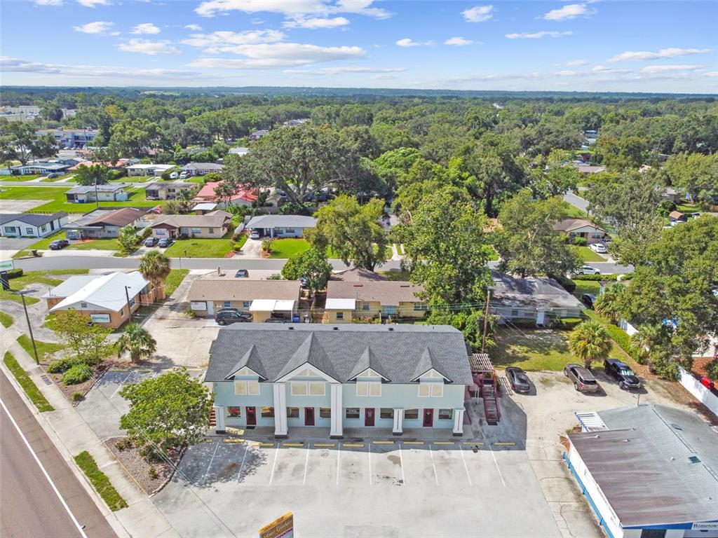 An aerial view shows a light green multi-unit commercial building with a large parking lot — 1137 BARTOW ROAD UNIT 206, LAKELAND, FL