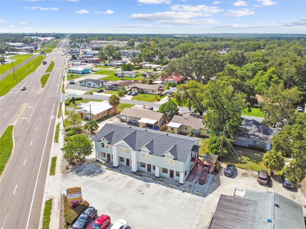 An aerial view shows a multi-unit commercial building with a parking lot beside a highway — 1137 BARTOW ROAD UNIT 206, LAKELAND, FL