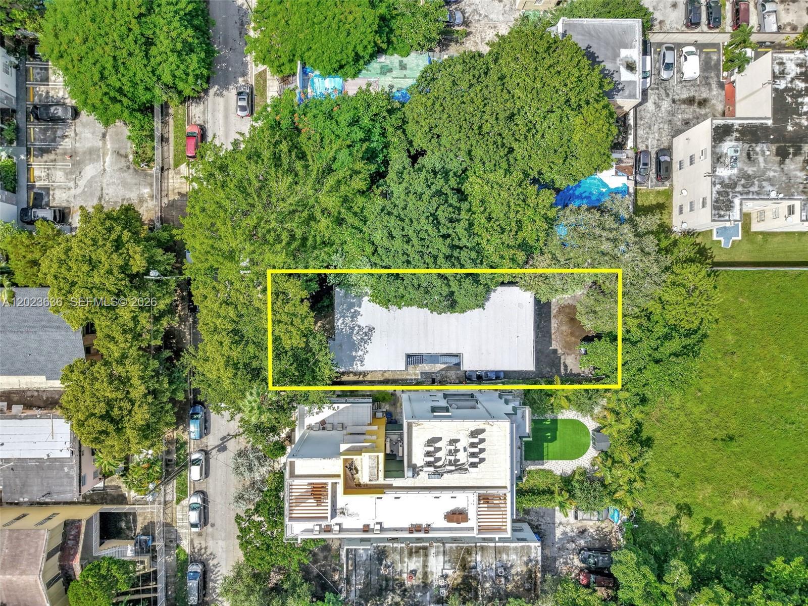 An aerial view shows a rectangular building with a white roof surrounded by dense trees — 641 NW 2nd St, Miami FL 33128, MIAMI, FL