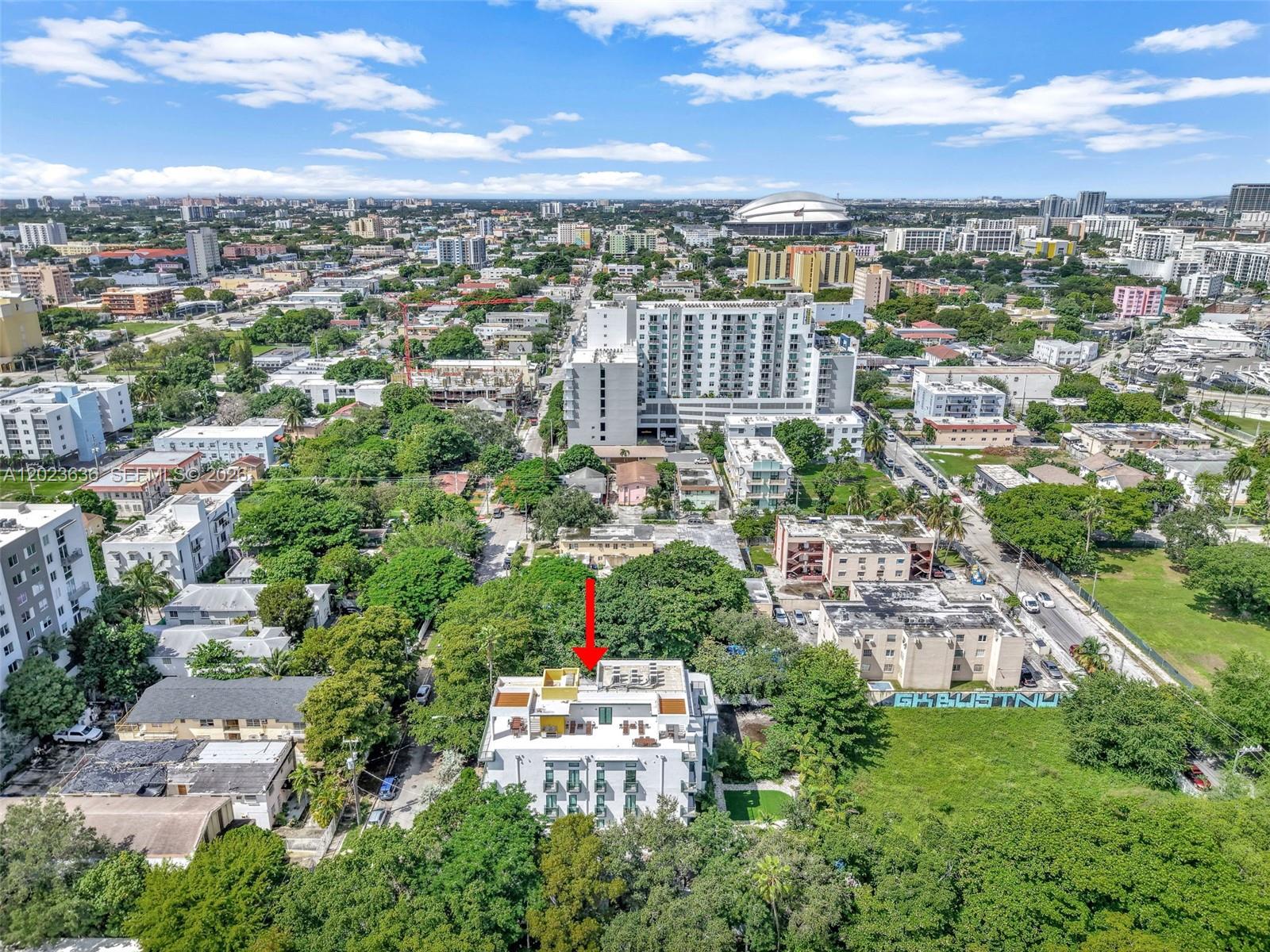 An aerial view shows a white multi-story apartment building surrounded by trees and urban development — 641 NW 2nd St, Miami FL 33128, MIAMI, FL