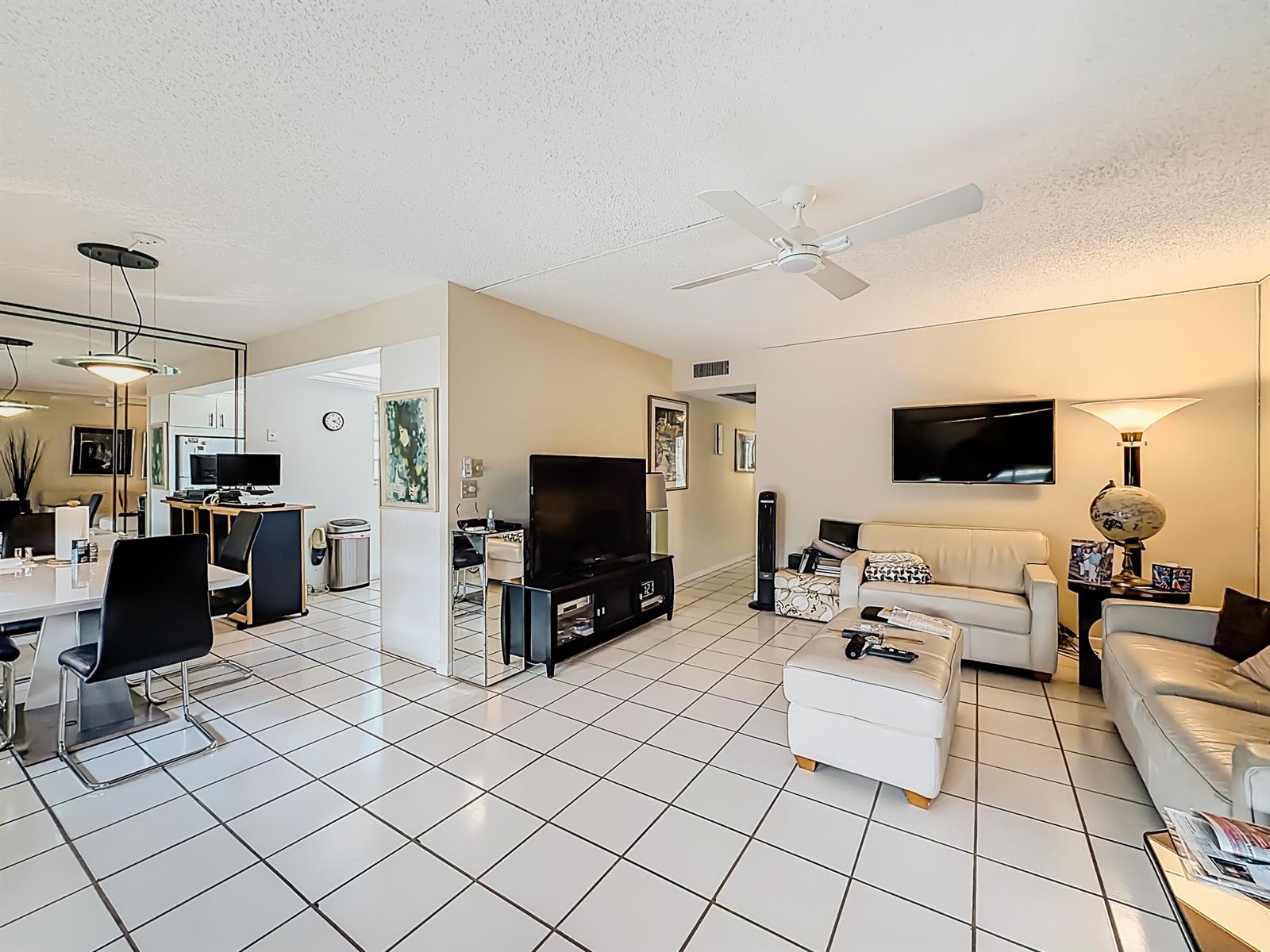A living room and dining area with white tile floors, a ceiling fan, and furniture — 2114 Oakridge V, Deerfield Beach FL 33442, DEERFIELD BEACH, FL