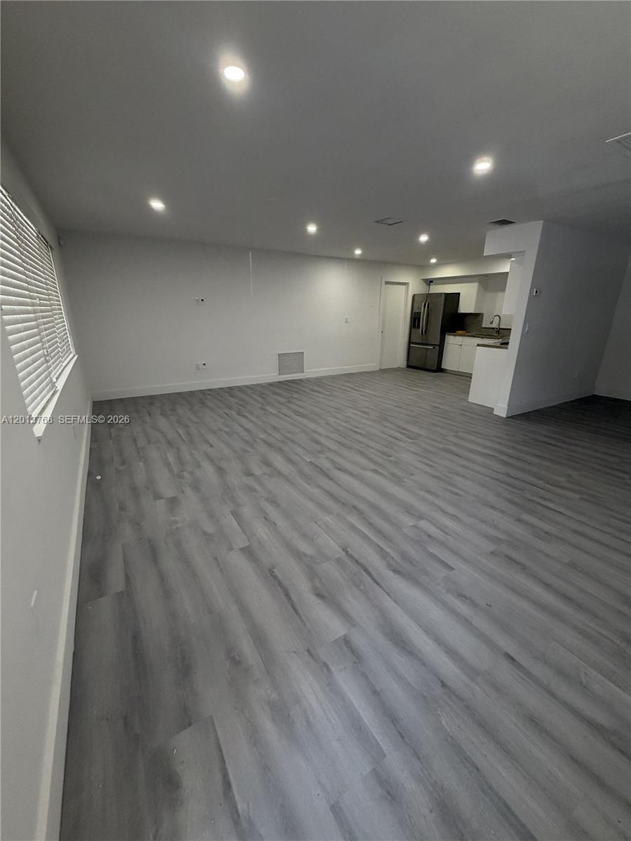 An open-concept living area features light gray wood-look flooring, recessed lighting, and an adjacent kitchen — 9401 SW 64th Ter # 0, Miami FL 33173, MIAMI, FL