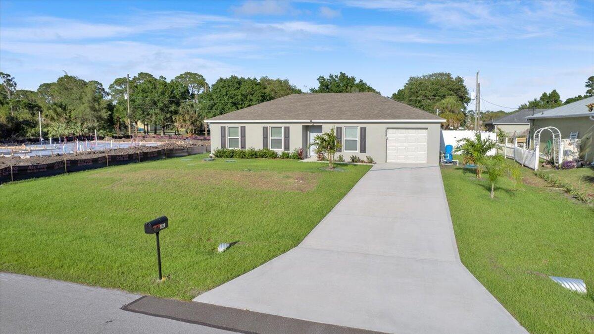 A single-story house with a gray exterior, a concrete driveway, and a front lawn — 3129 Wessel Avenue SE, Palm Bay FL 32909, PALM BAY, FL