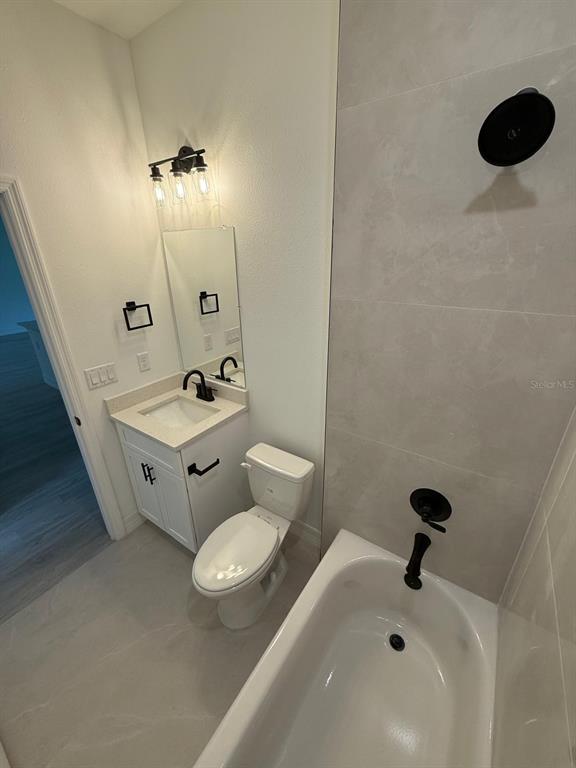 A bathroom features a white vanity, a toilet, and a bathtub with a tiled surround — 2190 W ARBUTUS DRIVE, CITRUS SPRINGS, FL