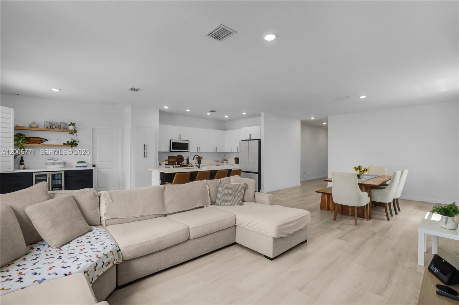 An open-concept living area features a sectional sofa, a dining set, and a modern kitchen — 14836 SW 162nd St, Miami FL 33187, MIAMI, FL