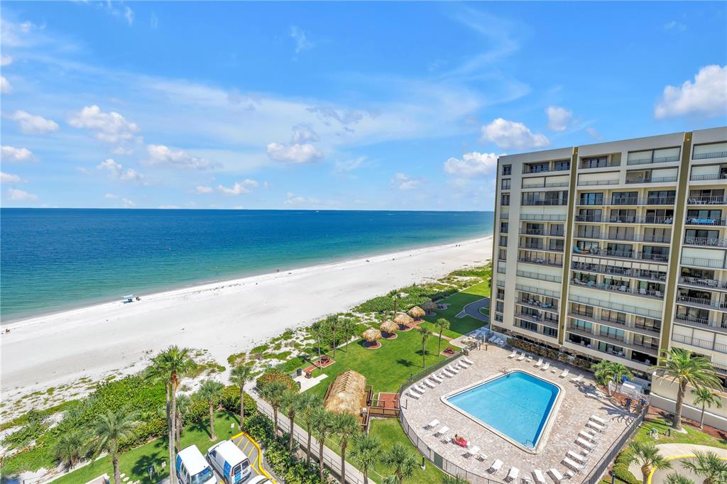 An aerial view of a beachside resort featuring a swimming pool and white sand beach — 1520R GULF BOULEVARD UNIT 906, CLEARWATER BEACH, FL