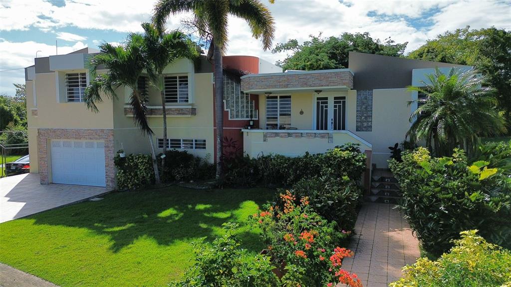A two-story house with a garage, palm trees, and a landscaped front yard — 1117 CALLE VIRGINIA BARRETO GARCIA, QUEBRADILLAS, PR