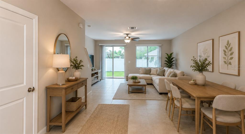 An exterior view of a multi-unit townhouse building with gray stucco walls and brown garages — 817 ROYAL EMPRESS DRIVE, RUSKIN, FL