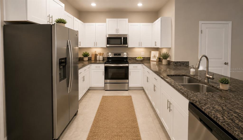 An aerial view of a multi-unit townhouse complex with attached garages and palm trees — 817 ROYAL EMPRESS DRIVE, RUSKIN, FL