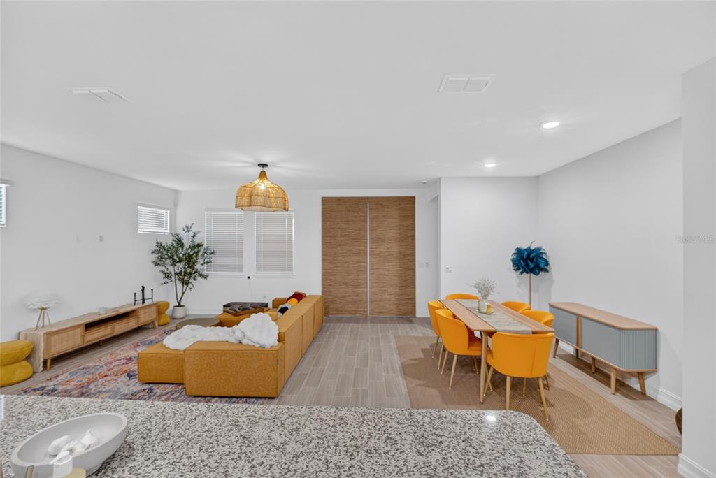 An open-concept living and dining area features tile flooring, yellow furniture, and a kitchen island — 3231 NW 52ND AVENUE ROAD, OCALA, FL