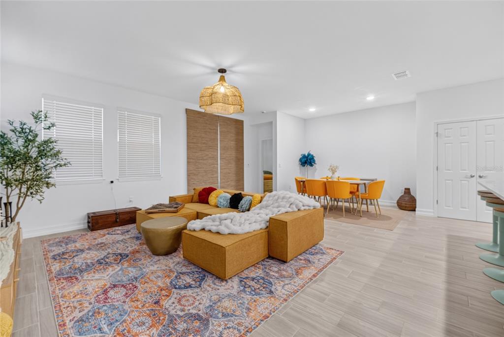 A living room and dining area feature a yellow sectional sofa, area rug, and chairs — 3231 NW 52ND AVENUE ROAD, OCALA, FL