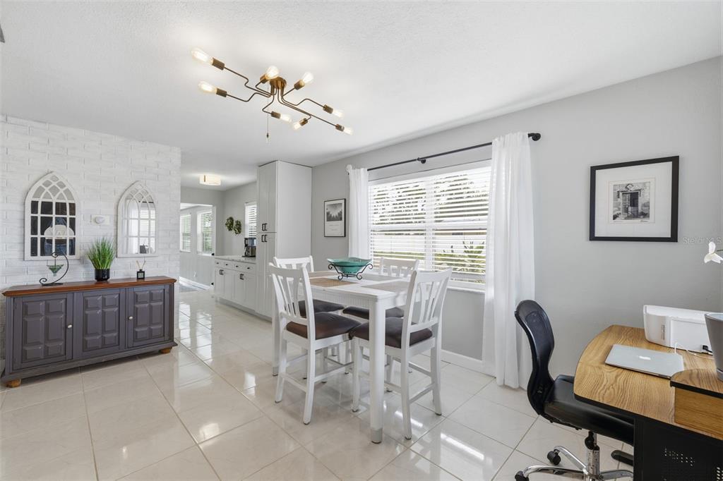 A dining area features a white table, chairs, a gray sideboard, and a modern light fixture — 801 89TH AVENUE N, ST PETERSBURG, FL