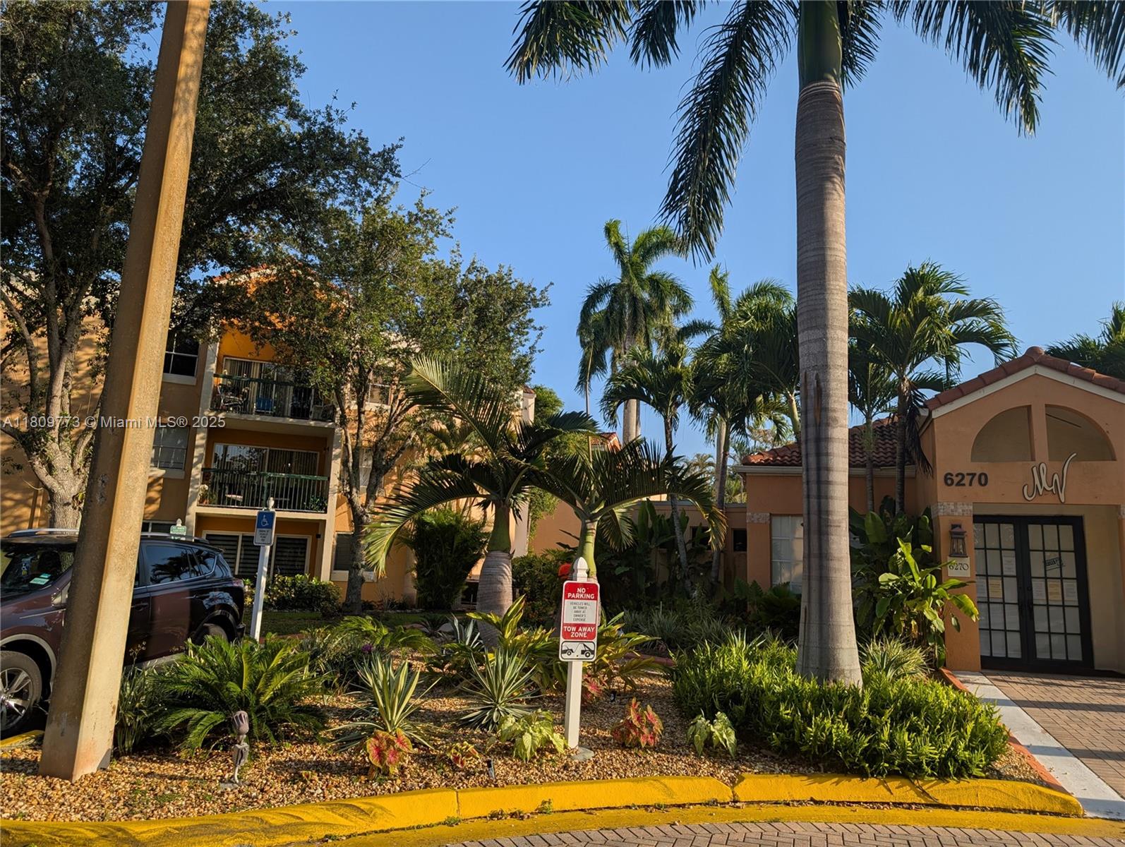 An exterior view shows a multi-story apartment building with palm trees and a parking sign — 6276 NW 186th St # 305, Hialeah FL 33015, HIALEAH, FL