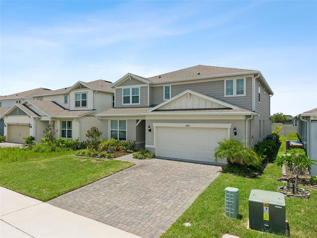 A two-story suburban house with a paved driveway, a two-car garage, and a lawn — 5668 ARBORVISTA STREET, ST CLOUD, FL