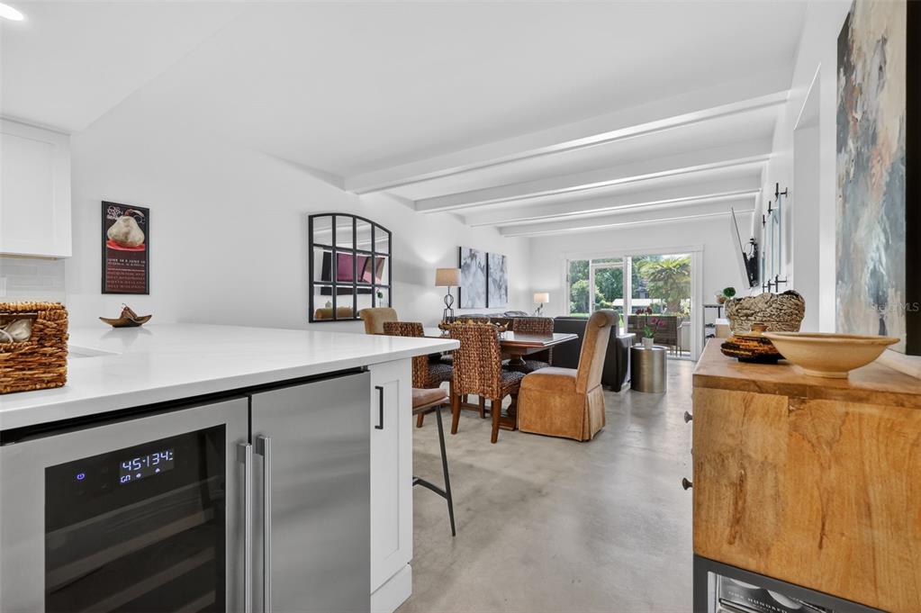 A kitchen island with a wine cooler overlooks a dining area and a living room — 101 N GRANDVIEW STREET UNIT 1, MOUNT DORA, FL