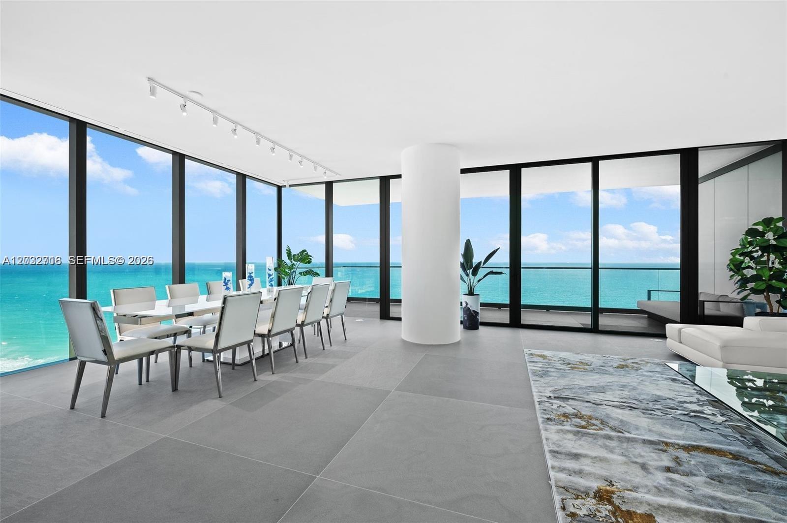 A modern dining area features floor-to-ceiling windows with ocean views and large gray tiles — 2000 S Ocean Dr # 25A, Hallandale Beach FL 33009, HALLANDALE BEACH, FL