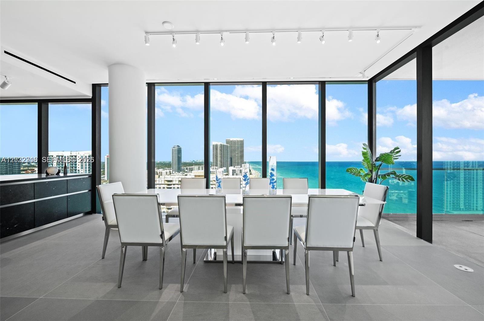 A modern dining room features a white table, eight chairs, and floor-to-ceiling ocean views — 2000 S Ocean Dr # 25A, Hallandale Beach FL 33009, HALLANDALE BEACH, FL