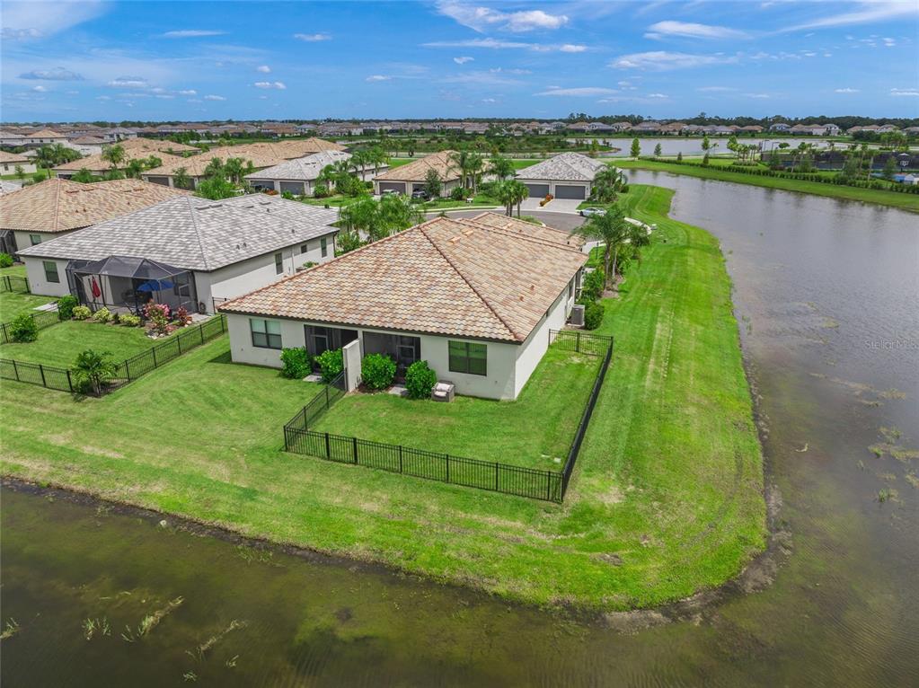 An aerial view of a suburban house with a tiled roof and a fenced backyard — 15982 CLEAR SKIES PLACE, BRADENTON, FL