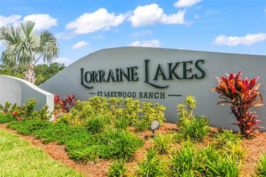 A curved stone monument sign displays the name Lorraine Lakes at Lakewood Ranch outdoors — 15982 CLEAR SKIES PLACE, BRADENTON, FL