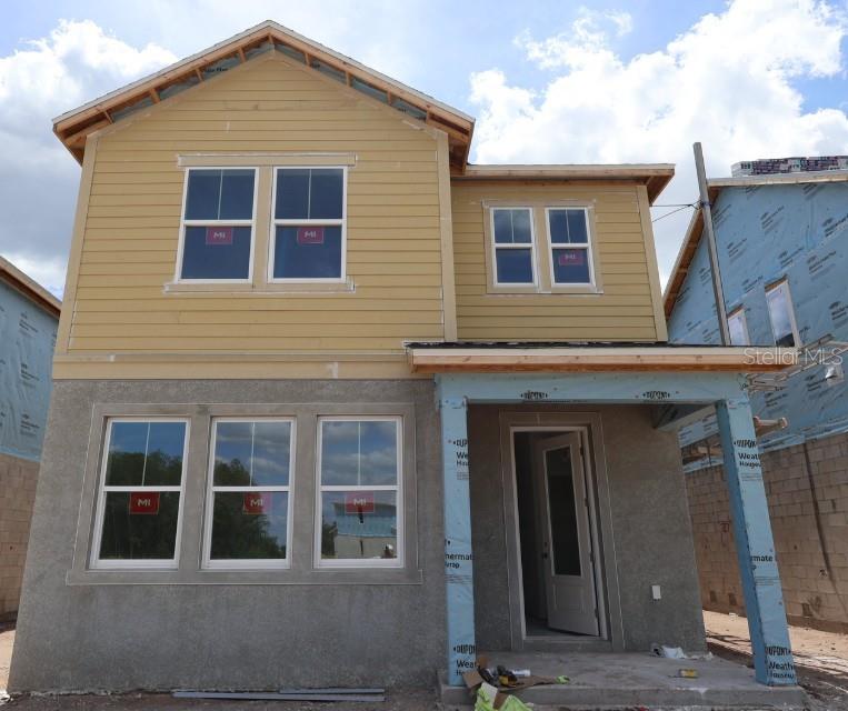 A two-story house under construction with yellow siding, stucco, and a front porch — 2823 CRIMSON CAP STREET, ODESSA, FL