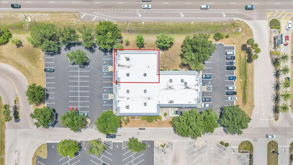 This aerial view shows a commercial building with a flat roof and surrounding parking lots — 3300 TAMIAMI TRAIL UNIT 2, PORT CHARLOTTE, FL