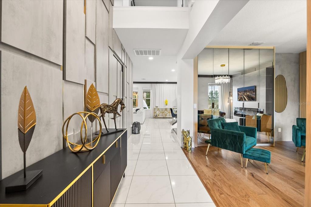 A modern entryway with white tile floors leads to a living area with wood flooring — 8109 LUDINGTON CIRCLE, ORLANDO, FL