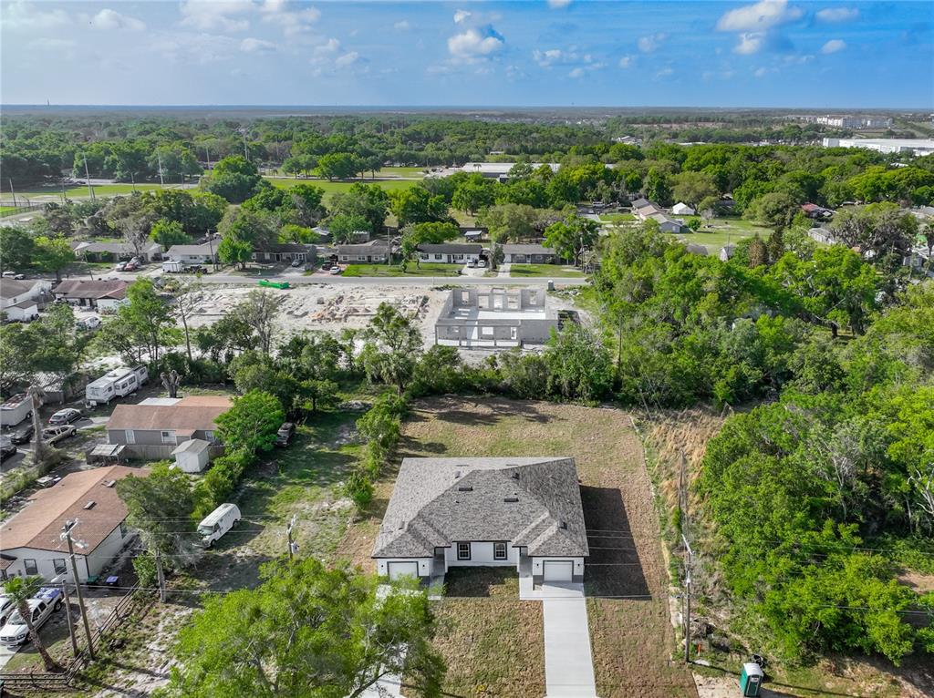 An aerial view shows a newly constructed house with a gray roof and concrete driveway — 356 W 4TH STREET, APOPKA, FL